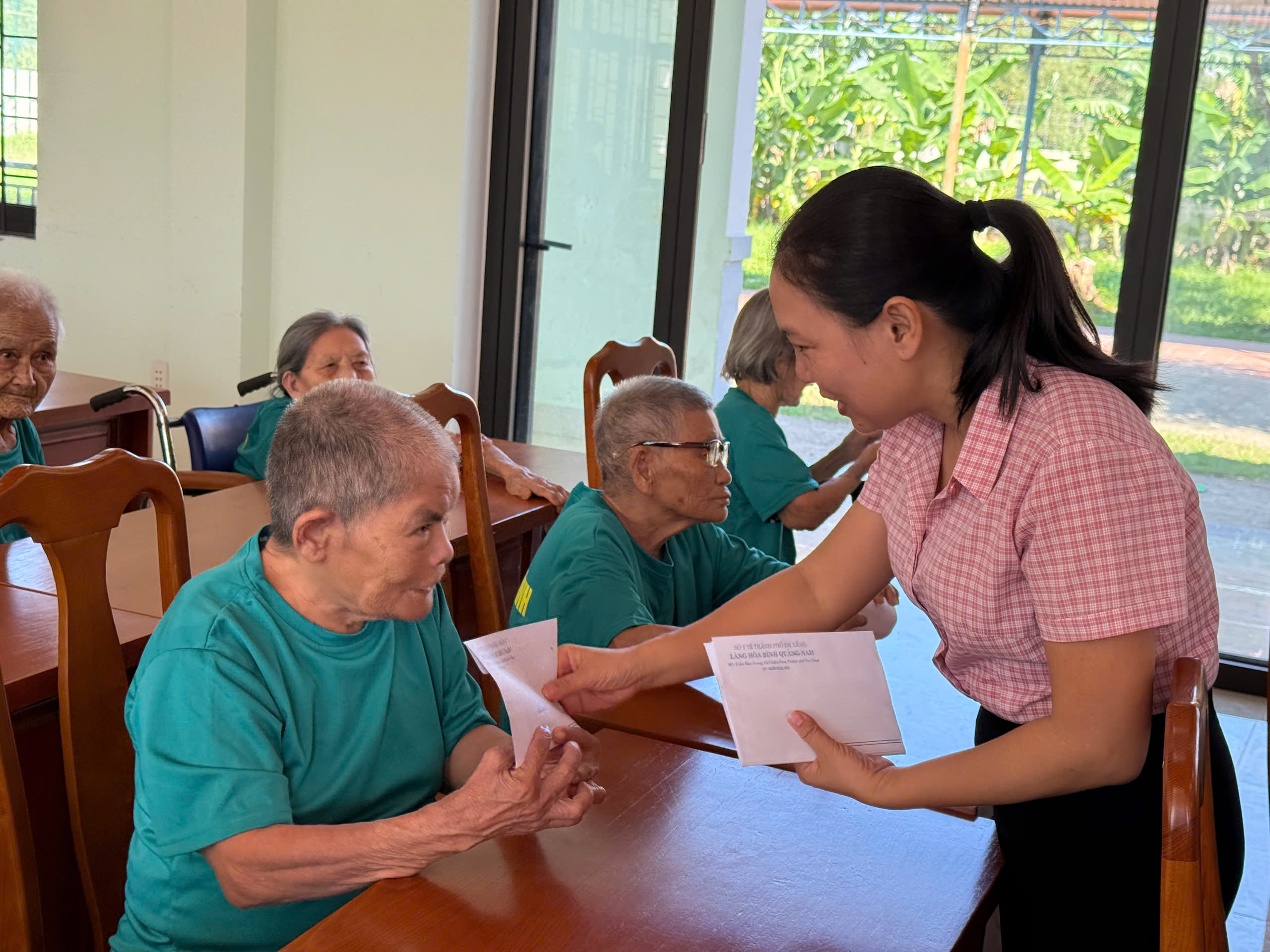 Bà Đinh Thị Liễu xuống trao quà cho các cụ đi lại khó khăn